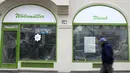 Seorang pria melewati toko daging yang tutup di Munich, Jerman, Selasa (23/3/2021). Jerman juga memberlakukan beberapa pembatasan baru, termasuk menutup sebagian besar kehidupan publik selama Paskah, dalam upaya menurunkan infeksi virus corona. (AP Photo/Matthias Schrader)