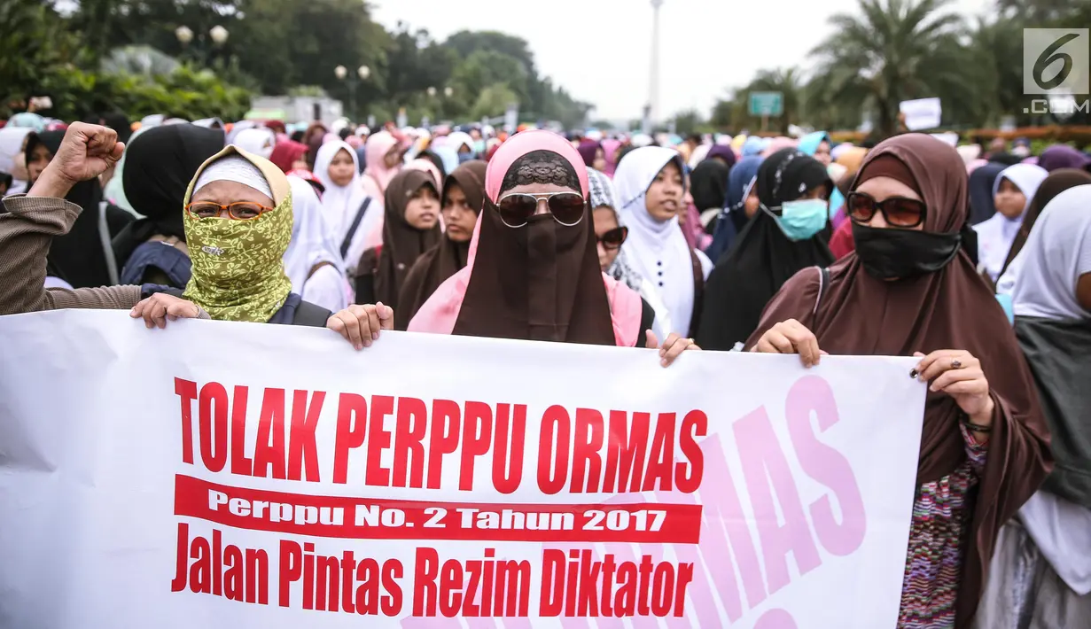 Peserta aksi wanita membentangkan spanduk saat berunjuk rasa di Pintu Barat Monas, Jakarta, Selasa (18/7). (Liputan6.com/Faizal Fanani)