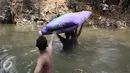 Sejumlah warga membawa kasur menyeberangi kali Ciliwung usai penggusuran di Kampung pulo, Jakarta, Jumat (21/8/2015). Penggusuran terkait rencana Pemprov DKI Jakarta yang akan melakukan normalisasi Kali Ciliwung. (Liputan6.com/Gempur Surya)