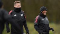 Gelandang Manchester United, Antonio Valencia (kanan) tersenyum saat mengikuti latihan tim jelang menghadapi Sevilla pada leg kedua babak 16 besar Liga Champions di dekat Carrington, Inggris (12/3). (AFP Photo/Oli Scarff)