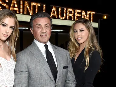 Sylvester Stallone (tengah) berpose dengan dua putrinya, Sistine Stallone (kiri) dan Sophia Stallone saat menghadiri Saint Laurent Fall Collection di Los Angeles, California, Rabu (10/2/2016). (Larry Busacca/Getty Images for SAINT LAURENT)