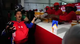 Ekspresi dari seorang suporter usai menerima minuman bir yang disediakan di sebuah stan saat pembukaan FIFA Fan Festival Piala Dunia 2022 di Taman Al Bidda, Doha, Qatar (19/11/2022). (AP Photo/Petr David Josek)