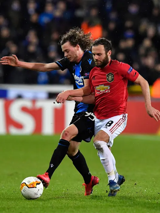 Pemain Club Brugge,  Maxim De Cuyper (kiri) berebut bola dengan gelandang Manchester United, Juan Mata dalam leg pertama babak 32 besar Liga Europa di Jan Breydelstadion, Kamis (20/2/2020). Manchester United gagal meraih hasil maksimal usai ditahan imbang Club Brugge 1-1. (JOHN THYS / AFP)