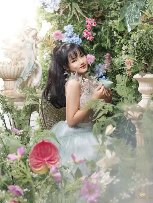 Wanita kelahiran 2002 itu tampak begitu anggun mengenakan gaun floral bernuansa pastel. Berbeda dari biasanya, ia pun tampil dengan rambut panjang berwarna hitam dan berponi. Sambil tersenyum, paras ayu Fuji berhasil memikat netizen. (Liputan6.com/IG/@fuji_an)