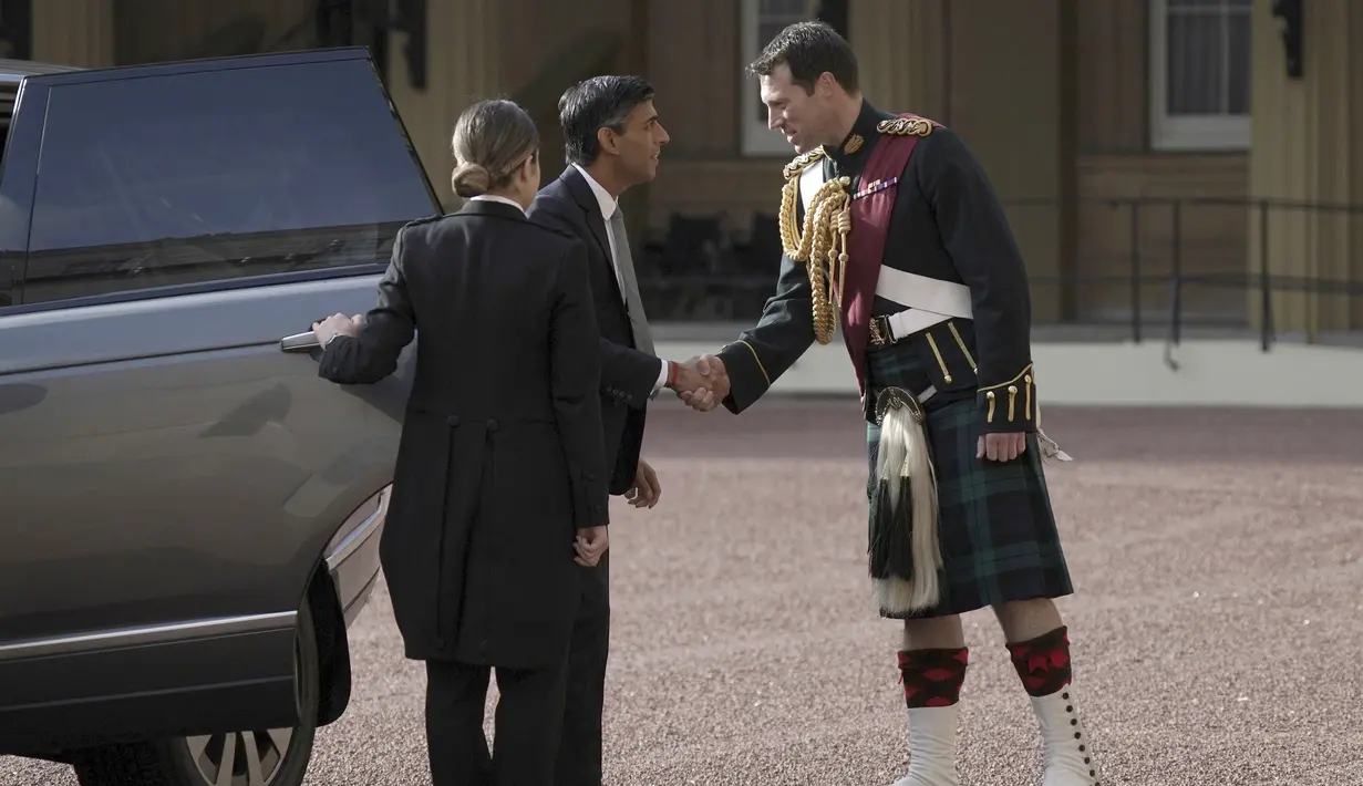 Rishi Sunak disambut oleh penunggang kuda Raja Charles III, Letnan Kolonel Johnny Thompson, saat ia tiba di Istana Buckingham untuk audiensi dengan Raja Charles III di mana ia akan diundang untuk menjadi Perdana Menteri dan membentuk pemerintahan baru, di London, Selasa 25 Oktober , 2022. (Yui Mok/Pool Photo via AP)