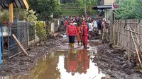 Jalan di Desa Bulukerto terendam lumpur dan sedang dalam upaya pembersihan oleh tim SAR Gabungan pasca banjir bandang di Kota Batu (Liputan6.com/Zainul Arifin)