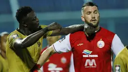 Striker Persija Jakarta, Marko Simic (kanan) saling dorong dengan striker Bhayangkara Solo FC, Ezechiel N'Douassel, pada laga Piala Menpora 2021 di Stadion Kanjuruhan, Malang, Rabu (31/3/2021). Persija Menang dengan skor 2-1. (Bola.com/M Iqbal Ichsan)