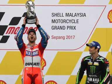 Pebalap Ducati, Andrea Dovizioso, melakukan selebrasi usai menjuarai balapan MotoGP Malaysia di Sirkuit Sepang, Minggu (29/10/2017). Dovizioso finis pertama dengan catatan waktu 44 menit 51,497 detik. (AFP/Mohd Rasfan)
