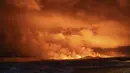 Langit malam diterangi cahaya akibat letusan gunung berapi di Grindavik di Semenanjung Reykjanes Islandia, Senin (18/12/2023). (AP Photo/Marco Di Marco)