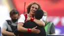 Bek Arsenal, David Luiz, memeluk Mikel Arteta, usai menjuarai Piala FA di Stadion Wembley, London, Sabtu (1/8/2020). Arsenal menang 2-1 atas Chelsea. (Catherine Ivill/Pool via AP)