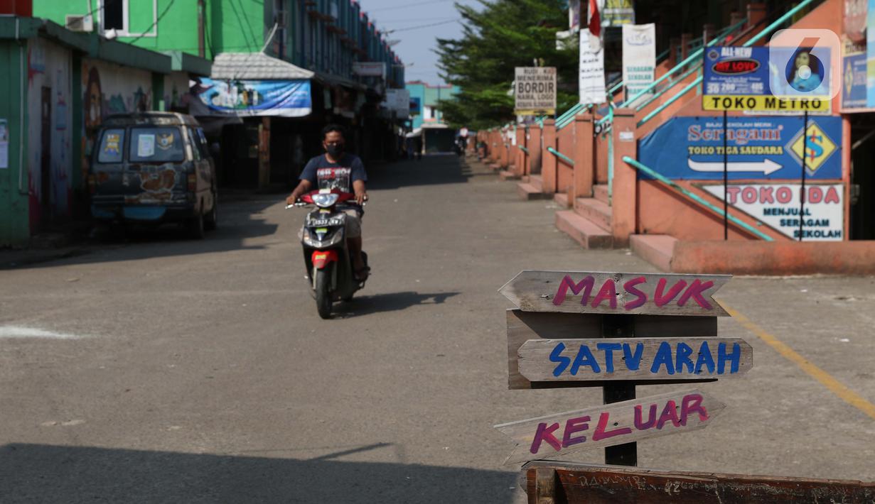 Warga melintasi pintu masuk kawasan Pasar Cileungsi yang ditutup sementara, Kabupaten Bogor, Selasa (2/6/2020). Penutupan sementara kegiatan jual beli di Pasar Cileungsi terkait adanya tujuh pedagang yang positif terinfeksi virus COVID-19. (Liputan6.com/Helmi Fithriansyah)