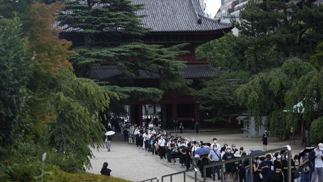 Orang-orang mengantre sebelum berdoa untuk memberi penghormatan ke mantan Perdana Menteri Jepang Shinzo Abe di Kuil Zojoji sebelum pemakamannya di Tokyo pada Selasa, 12 Juli 2022. (Foto AP/Hiro Komae)
