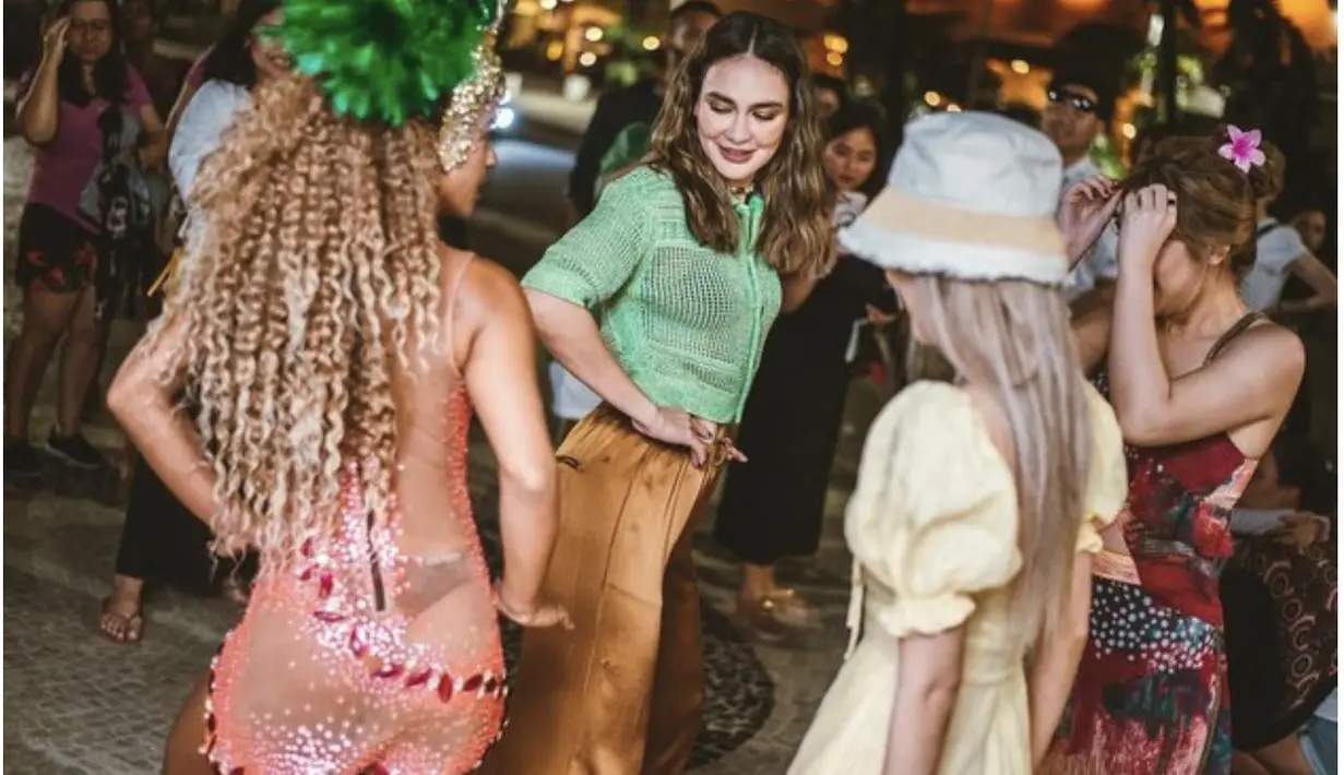 Kemeja see through bernunsa hijau dan celana satin keemasan menambah kesan bold pada penampilannya. [Foto/ Instagram/ Luna Maya]