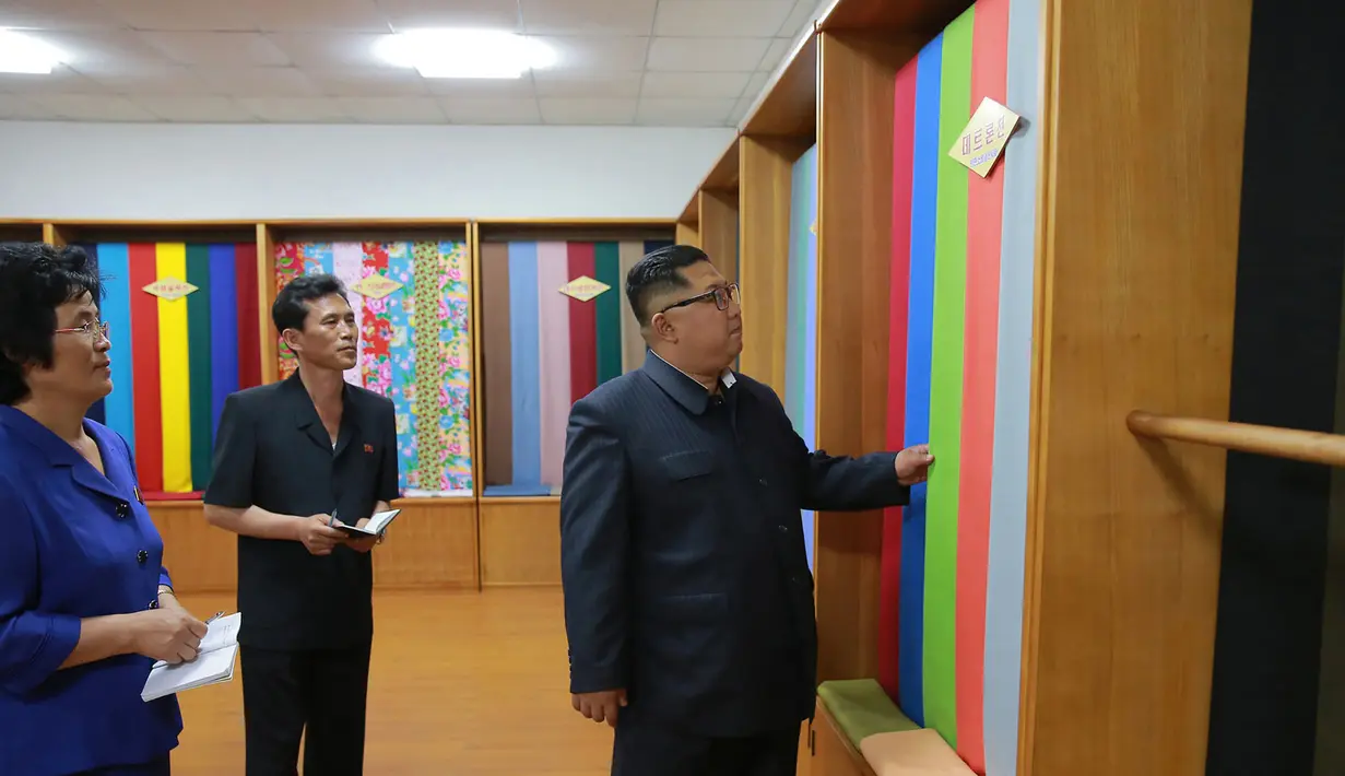 Pemimpin Korea Utara, Kim Jong-un melihat bahan saat mengunjungi Sinuiju Chemical Fiber Mill di Sinuiju, Korea Utara (2/7). (AFP Photo/KCNA Via KNS)