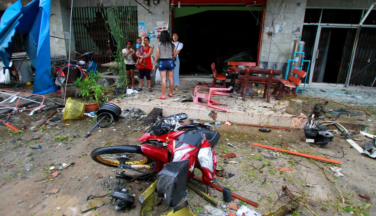 Warga berada di tempat kejadian setelah ledakan bom mobil di Southern Hotel, Provinsi Pattani, Thailand, Rabu (24/8). Diketahui ada dua bom yang meledak di sekitar Southern Hotel di kawasan Pantai Pattani, Thailand Selatan. (REUTERS/Surapan Boonthanom)