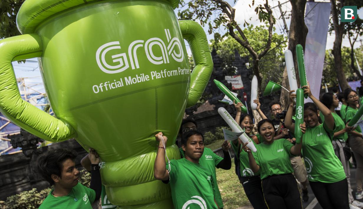 Sejumlah mitra dari Grab membawa balon raksasa saat pawai obor Asian Games XVIII di Denpasar, Bali, Selasa (24/7/2018). Sebanyak 53 kota di Indonesia akan dilalui oleh obor Asian Games. (Bola.com/Vitalis Yogi Trisna)