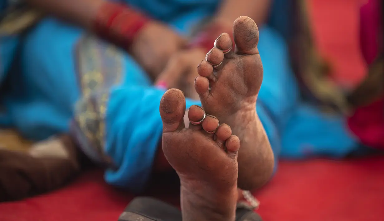 Seorang petani perempuan duduk di sebuah protes dalam solidaritas dengan petani, di Mumbai, India, Minggu  (28/11/2021). Kelompok tani menunggu undang-undang pertanian yang kontroversial untuk secara resmi ditarik selama sesi parlemen yang dijadwalkan akan dimulai Senin. (AP Photo/Rafiq Maqbool)