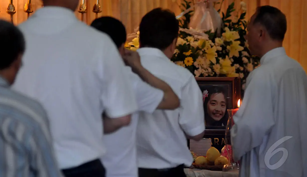 Keluarga memanjatkan doa di depan jenazah korban pesawat AirAsia QZ8501, Grayson Herbert Linaksita yang disemayamkan di rumah duka Adi Jasa, Surabaya, Minggu (4/1/2015). (Liputan6.com/Johan Tallo)