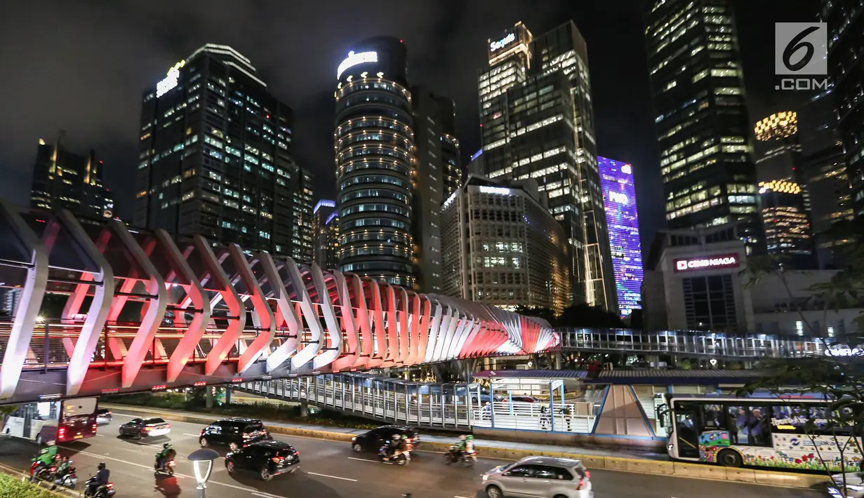 Suasana Jembatan Penyeberangan Orang (JPO) Gelora Bung Karno di Jalan Jend Sudirman, Jakarta, Senin (4/3) malam. JPO tersebut menjadi daya tarik tersendiri bagi pejalan kaki karena desainnya yang artistik dan Instagramable. (Liputan6.com/Fery Pradolo)