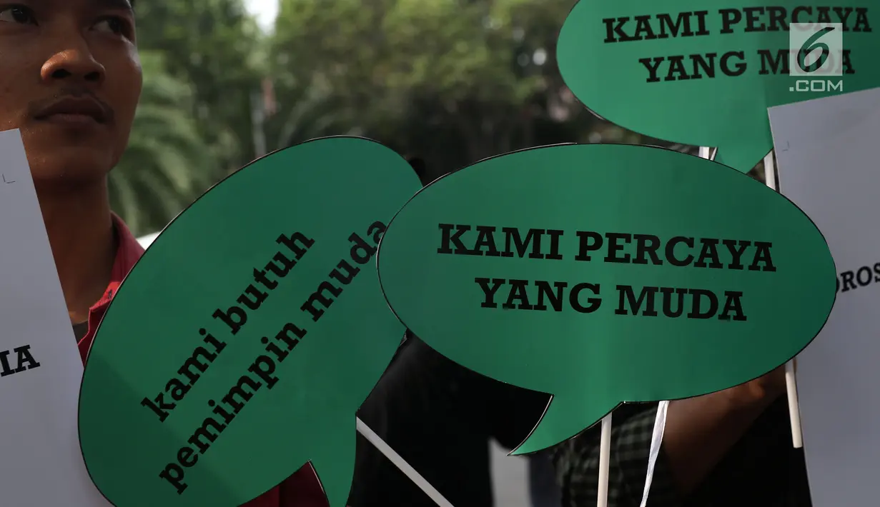Aktivis Poros Indonesia Muda saat melakukan aksi dengan membawa balon bertempelkan gambar politisi muda di Gedung KPU, Jakarta, Rabu (1/8). Mereka berharap Pemilu 2019 mendapatkan pilihan yang membawa aspirasi kaum muda. (Liputan6.com/Helmi Fithriansyah)