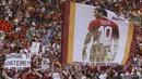 Supporter membawa bendera raksasa bergambar Francesco Totti saat laga terakhir sang legenda di Stadion Olimpico, Roma, Minggu (28/5/2017). Selama 25 tahun Totti berkarier di AS Roma. (AP/Alessandra Tarantino)