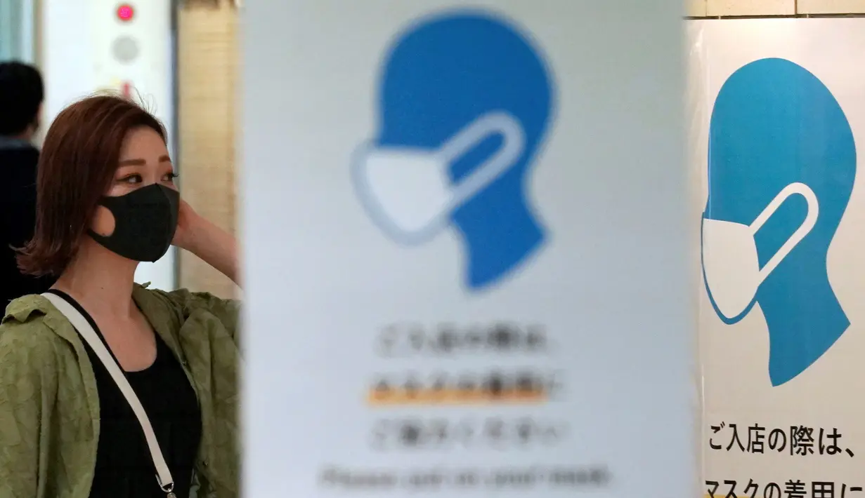 Seorang wanita yang mengenakan masker untuk mencegah penyebaran COVID-19 berjalan di Tokyo, Jepang, Jumat (3/7/2020). Tokyo melaporkan lebih dari 100 kasus baru COVID-19 pada hari 3 Juli 2020. (AP Photo/Eugene Hoshiko)