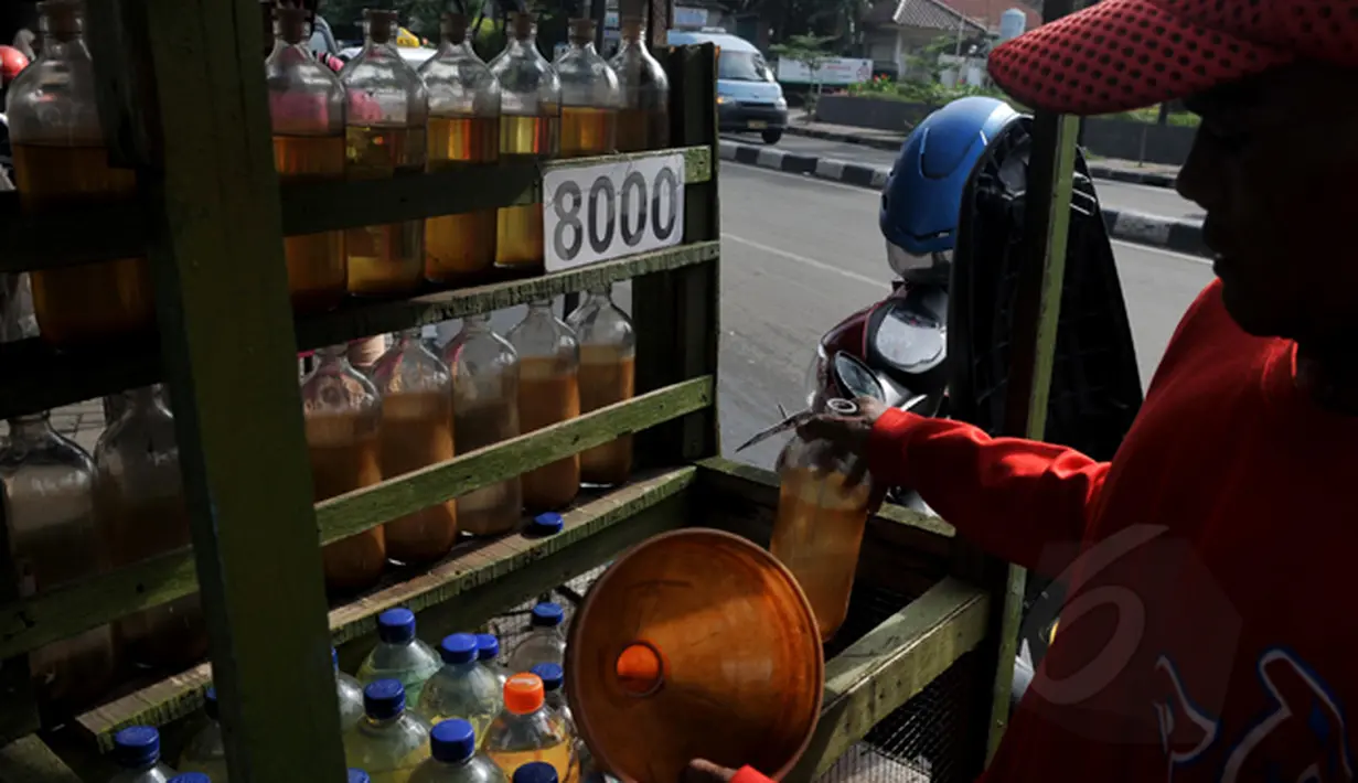 Pedagang melayani pembelian bensin eceran jenis premium di kawasan Petamburan, Jakarta, Senin (2/3/2015). Pemerintah kembali menaikkan harga BBM jenis Premium sebesar Rp 200 per liter per 1 Maret 2015 pukul 00.00 WIB. (Liputan6.com/Johan Tallo)