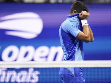 Petenis asal Serbia, Novak Djokovic, tak kuasa menahan tangis dengan menutupi wajahnya setelah berhasil merebut gelar juara US Open 2023 yang berlangsung di Arthur Ashe, New York, Senin (11/9/2023) pagi WIB. Novak Djokovic berhasil mengalahkan Daniil Medvedev yang berasal dari Rusia dengan skor 6-3, 7-6(7-5), 6-3. (AP Photo/Charles Krupa)