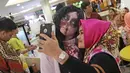 Pengunjung berselfie dengan kuntilanak di pusat perbelanjaan kawasan Sudirman, Jakarta, (31/10). Salah satu pusat perbelanjaan di kawasan Sudirman menghadirkan 3 cosplay, Zombie, Kuntilanak dan valak merayakan Halloween. (Liputan6.com/Herman Zakharia)