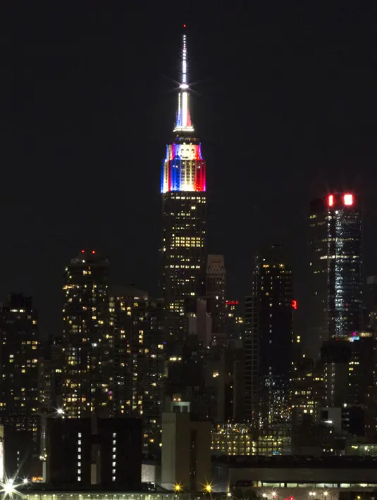 Lampu warna bendera juara Piala Dunia 2018, Prancis, mewarnai gedung pencakar langit Empire State di New York, Minggu (15/7). Meski gagal lolos Piala Dunia 2018, Amerika Serikat memiliki cara tersendiri memeriahkan ajang itu. (AFP PHOTO / KENA BETANCUR)