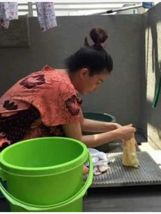 Wendah sedang mencuci baju putrinya. Meski mencuci pakaian bisa dengan mesin, tapi Wendah mencucinya dengan papan pengilasan untuk mencuci. (Instagram/ruben_onsu)