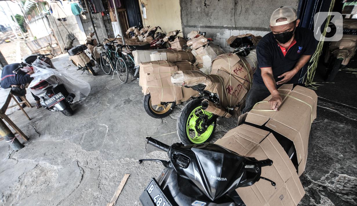 Pekerja mengemas sepeda motor sebelum dikirim via jasa ekspedisi kereta api di Jalan Bungur Raya, Senen, Jakarta, Senin (3/5/2021). Salah satu perusahaan jasa ekspedisi ini mengaku peningkatan mulai terjadi pada Kamis pekan lalu dengan pengiriman tujuan Jawa dan Bali. (merdeka.com/Iqbal S. Nugroho)