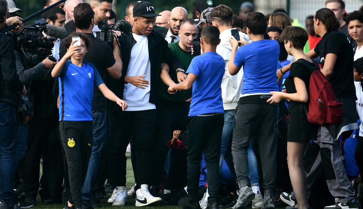 Bintang Prancis, Kylian Mbappe, menyapa fans saat mengunjungi markas AS Bondy di Paris, Rabu (17/10). Kunjungan ke klub pertamanya ini dilakukan setelah dirinya meraih gelar Piala Dunia 2018. (AFP/Anne-Christine Poujoulat)