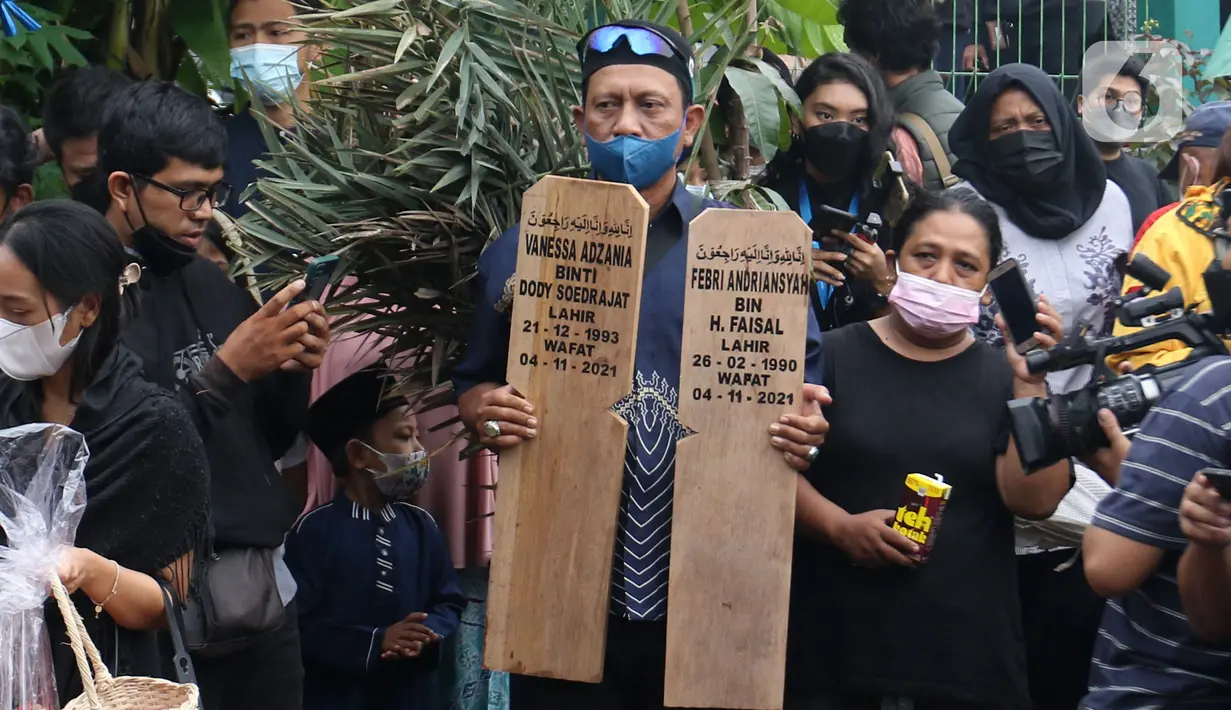 Seorang pria membawa patok saat pemakaman Vanessa Angel dan Bibi Ardiansyah di Taman Makam Islami Malaka, Pesanggrahan, Jakarta, Jumat (5/11/2021). Vanessa Angel dan Bibi Andriansyah meninggal dalam kecelakaan lalu lintas di Tol Mojokerto-Jombang pada 4 November 2021. (Liputan6.com/Herman Zakharia)