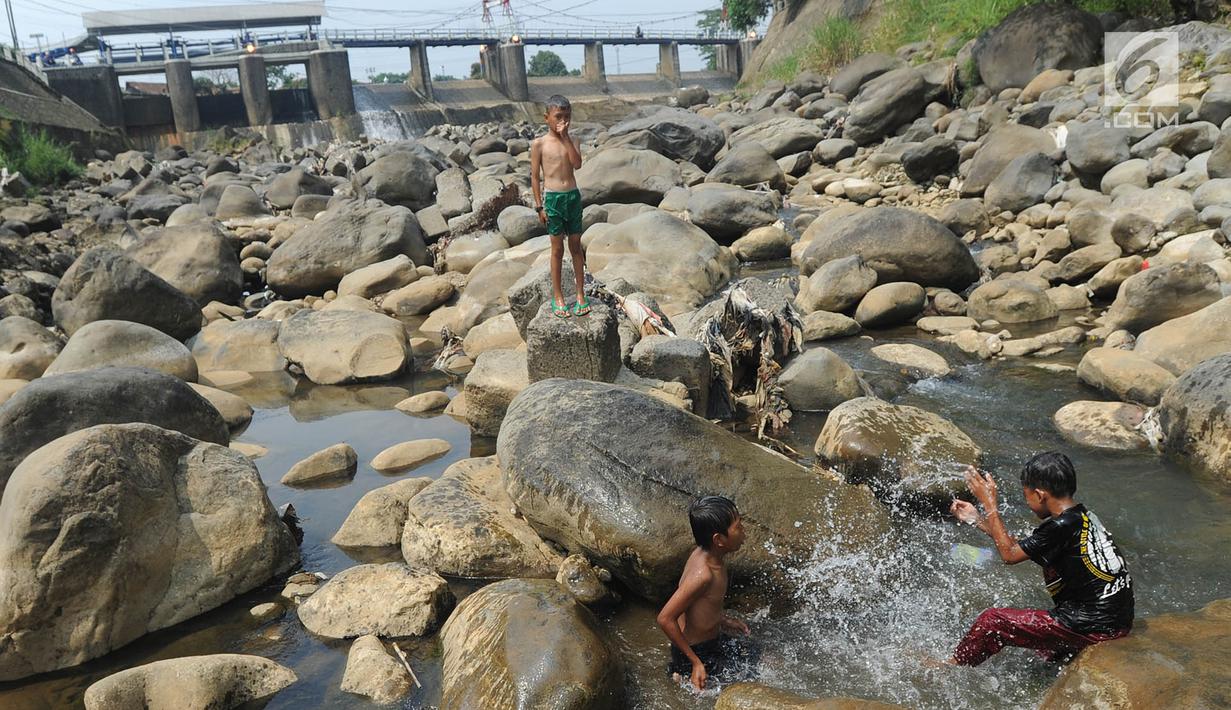 Anak-anak bermain pada kubangan air yang tersisa di kawasan Bendungan Katulampa, Bogor (15/7). Musim kemarau menyebabkan Bendungan Katulampa berada di titik nol berdampak pada sumur-sumur warga di sekitar mengalami kekeringan. (Merdeka.com/Arie Basuki)
