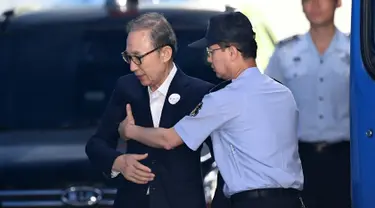 Mantan presiden Korea Selatan Lee Myung-bak (kiri) diperiksa petugas penjara ketika tiba di pengadilan untuk menghadiri persidangan di Seoul (6/9). Jaksa menuntut 20 tahun penjara Lee Myung-bak atas tuduhan korupsi. (AFP Photo/Jung Yeon-je)