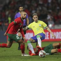 Gelandang Maroko, Sofyan Amrabat, berduel melawan pemain Brasil, Antony dalam laga uji coba di Grand Stade de Tanger, Tangier, Minggu (26/3/2023) pagi WIB. (AP/Mosha'ab Elshamy)