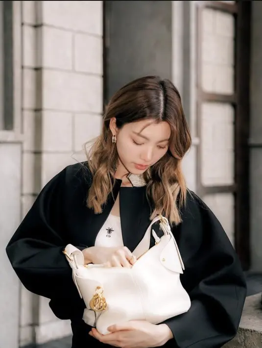 Kornaphat Sethratanapong tampil dengan warna kontras paduan oitfit dan tas Dior Voyage Bag monokrom. [Foto: Dior.dok]