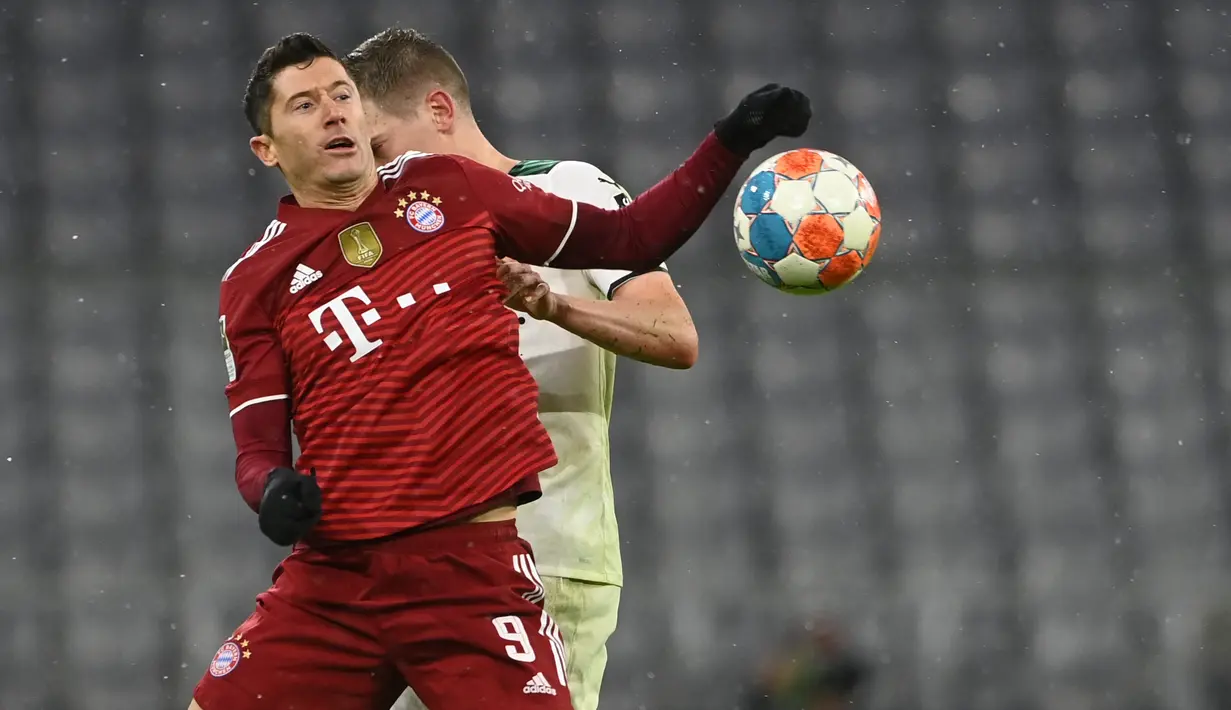 Penyerang Bayern Munchen Robert Lewandowski (Depan) berebut bola dengan bek Borussia Monchengladbach, Matthias Ginter pada laga pekan ke-18 Bundesliga di Allianz Arena, Sabtu (8/1/2022) dini hari WIB. Bayern Munchen dipermalukan di kandang sendiri 1-2. (CHRISTOF STACHE/AFP)