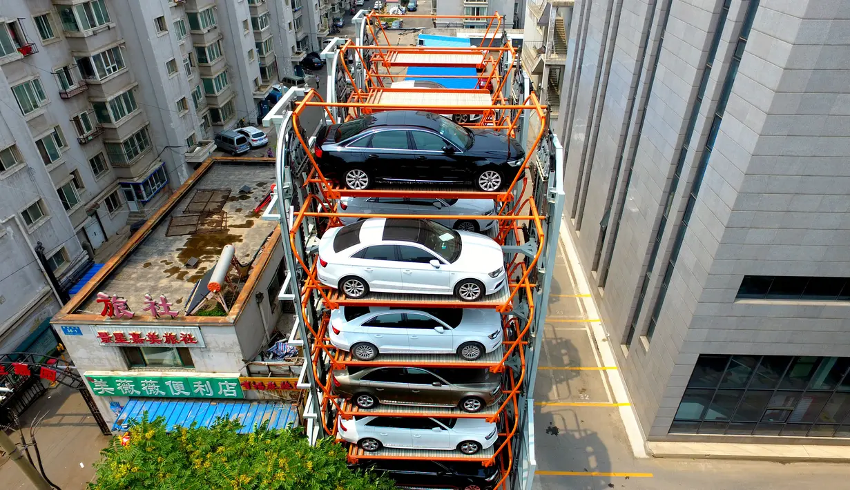 Sejumlah mobil parkir di parkiran bertingkat tiga dimensi di Shenyang, provinsi Liaoning, China  (19/6). Tempat parkir ini terbuat dari konstruksi besi yang dapat menampung hampir 40 mobil. (AFP Photo/Str/China Out)