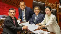 Rapat dipimpin oleh Ketua DPR RI Puan Maharani yang didampingi Wakil Ketua DPR yang lain, seperti Sufmi Dasco Ahmad, Saan Mustopa, dan Adies Kadir. Tampak dalam foto, Ketua Komisi I DPR RI yang juga Ketua Panja RUU TNI, Utut Adianto (kiri) menyerahkan naskah Rancangan Undang-Undang Tentara Nasional Indonesia (RUU TNI) kepada Ketua DPR RI Puan Maharani di Gedung DPR RI di Jakarta pada 20 Maret 2025. (RAQILLA/AFP)