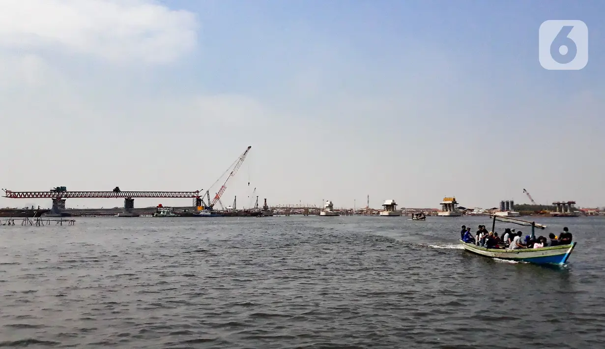 Kapal tradisional melintas dekat proyek pembangunan jembatan penghubung Dadap Tangerang-Pulau C di Kamal Muara, Penjaringan, Jakarta Utara, Minggu (17/11/2019). Pembangunan jembatan menyulitkan transportasi nelayan karena perairan menjadi sempit dan laut menjadi dangkal. (merdeka.com/Iqbal Nugroho)