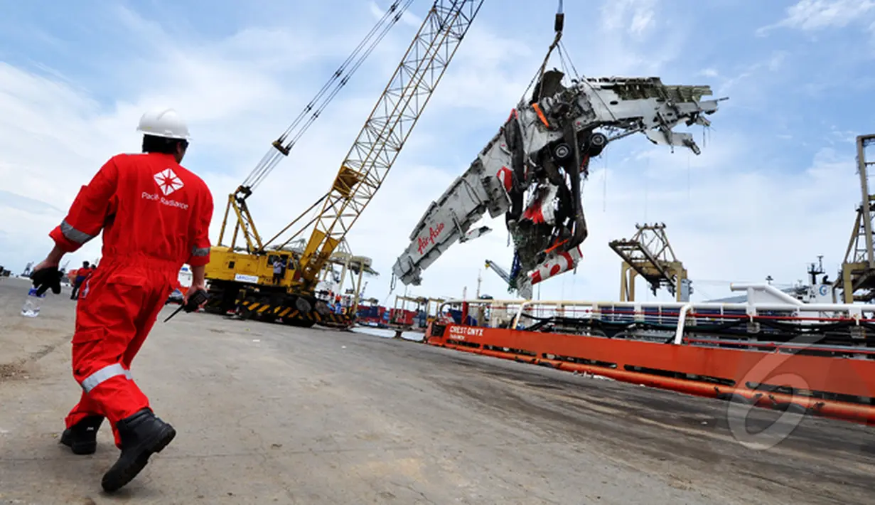 Petugas Basarnas dibantu alat berat saat memindahkan bangkai badan AirAsia QZ8501 dari kapal milik SKK Migas, Crest Onyx di Pelabuhan Tanjung Priok, Jakarta, Senin (2/3/2015).  (Liputan6.com/Faizal Fanani)