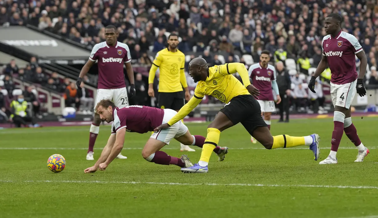 Penyerang Chelsea, Romelu Lukaku berebut bola dengan bek West Ham United, Craig Dawson pada pertandingan lanjutan Liga Inggris di stadion London di London Timur (4/12/2021). West Ham menang atas Chelsea dengan skor 3-2. (AP Photo/Alastair Grant)