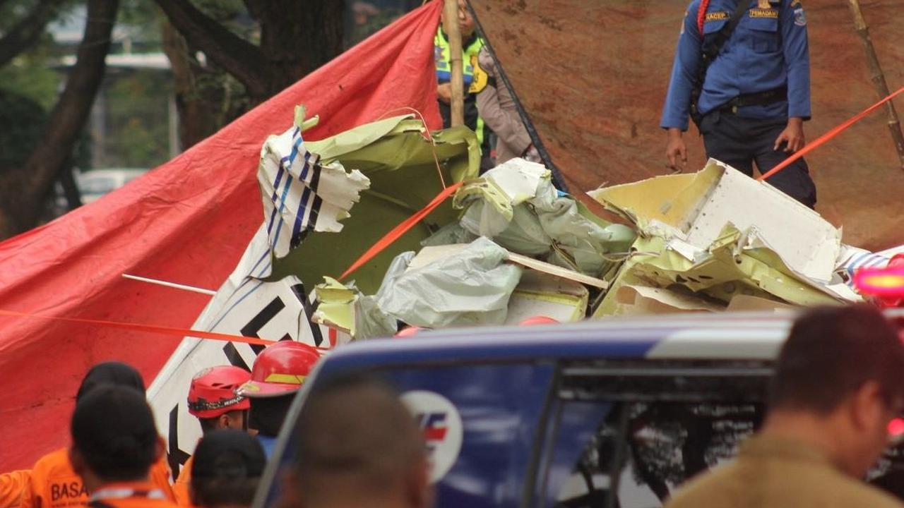 Proses evakuasi badan pesawat tersebut juga ditutup dengan terpal. Foto: merdeka.com / Arie Basuki