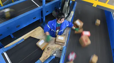 Seorang pekerja ZTO Express menyiapkan paket untuk dipindai dan didistribusikan di kawasan logistik tingkat provinsi di Wilayah Longli, Provinsi Guizhou, China pada 10 November 2020. Perusahaan-perusahaan logistik bersiap menyambut musim belanja "11.11" di China. (Xinhua/Dai Tianfang)