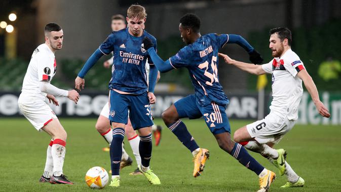 Striker Arsenal, Eddie Nketiah (kedua kanan) bersaing dengan gelandang Dundalk, Jordan Flores (kanan) pada pertandingan Grup B Liga Europa 2020/2021 di Stadion Aviva, Jumat (11/12/2020) dini hari WIB. Arsenal menang 4-2 saat bertandang di markas wakil Irlandia, Dundalk. (Paul Faith / AFP)