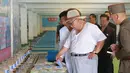 Pemimpin Korea Utara Kim Jong-un saat meninjau peternakan lele samchon di Provinsi Hwanghae Selatan, Korea Utara, Senin (6/8). Kim tampak santai dengan kaus putih tipis dan topi bundar. (KCNA VIA KNS/AFP)