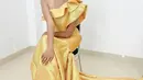 Tampilan gaun one shoulder lainnya dalam warna kuning mengilap dengan aksen ruffle yang manis