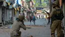 Polisi India mengarahkan senapan ke arah demonstran saat bentrok dengan warga Kashmir di Srinagar, India (11/7). Menurut kepolisian sebanyak 30 orang meninggal dalam bentrokan yang berlangsung selama tiga hari tersebut. (AFP PHOTO/Tauseef MUSTAFA)